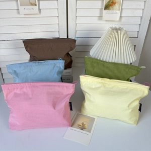 Flat lay of multiple nylon checkered cosmetic bags in pastel colors with zipper closure