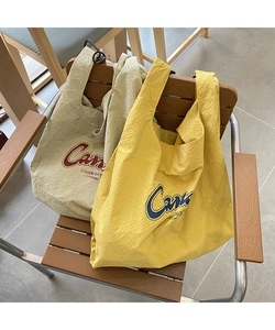 Detail of seersucker tote bag with vintage text print on rustic wooden chair