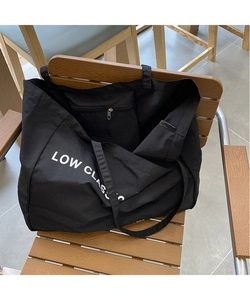 Detail view of the black canvas tote bag interior showing the secure metal zipper pocket