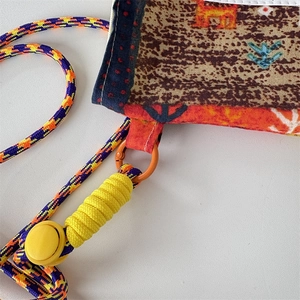 Detail of woven rope strap and printed fabric texture on ethnic style crossbody bag