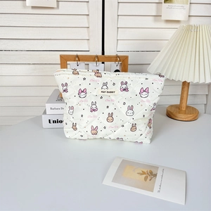 Détail d'une trousse de maquillage blanche matelassée aux motifs de lapins