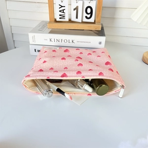 Detailed view of pink heart makeup bag interior holding brushes and cosmetics