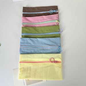 Detailed top view of five colorful nylon storage pouches with ring zippers and grid texture