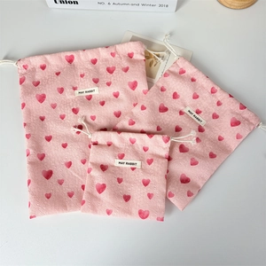 Pink drawstring storage bags in three sizes with heart pattern and cotton texture