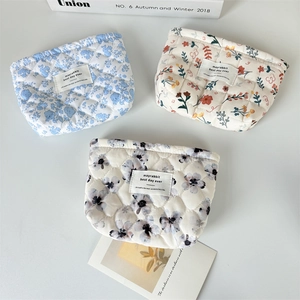 Three quilted cotton floral cosmetic bags in blue and colorful patterns shown in a group view