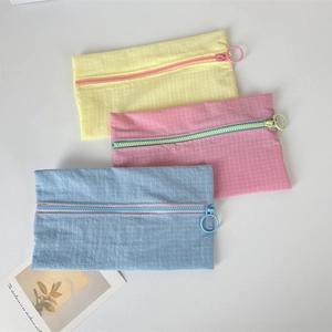Three colorful nylon grid pouches in yellow, pink, and blue with ring zipper pulls
