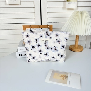 Détail de la trousse de maquillage en coton matelassé avec motif floral bleu élégant