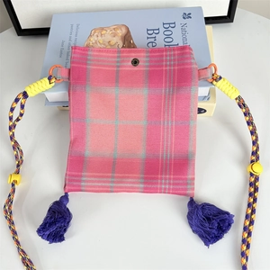 Detailed shot of vintage plaid crossbody mini bag with purple tassels and woven strap