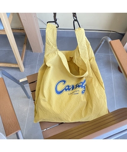 Detail of yellow waffle texture fabric tote bag featuring blue Candy art print and D-ring hook