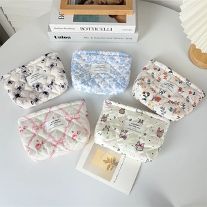 Five styles of large capacity floral quilted cotton cosmetic bags arranged on a white desk
