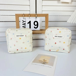 Détail de pochettes à fleurs avec fermeture éclair et étiquette tissée May Rabbit