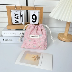 Dettaglio del sacchetto rosa a coulisse con graziosi cartoni animati di conigli e dolci