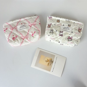 Detail view of quilted cotton cosmetic bags featuring floral and rabbit patterns