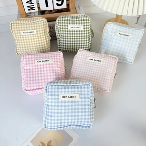 Detail of small checkered pouch with May Rabbit label and circular metal zipper pull