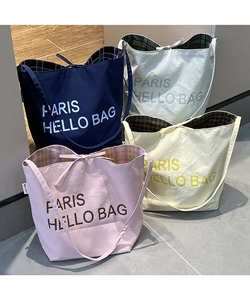 Macro shot of minimalist tote bags with letter prints and colorful checkered lining details
