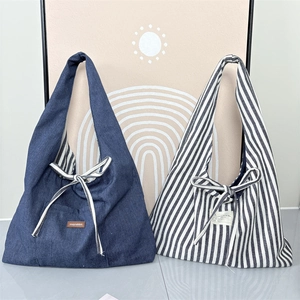 Detail of vintage tote bags in denim and striped canvas with bow tie closure detail