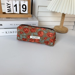 Detail of vintage floral corduroy stationery pouch with logo tag and metal zipper
