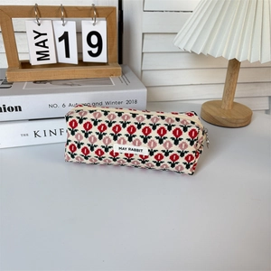 Detail of vintage floral corduroy pencil case with May Rabbit woven label on a cozy desk