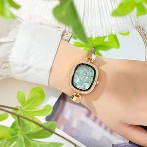 Close-up of elegant women watch with green marble dial and sparkling rhinestone bezel
