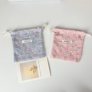 Dettaglio di sacchetti a coulisse trapuntati rosa e blu con stampe di orsetti cartoon