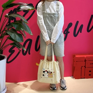 Beige drawstring canvas tote bag with cute cartoon dog embroidery and wide handles