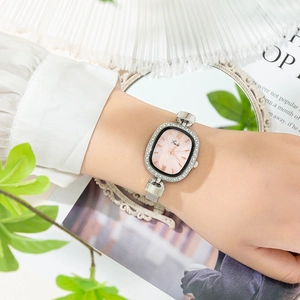 Detail of silver rectangular watch with crystal bezel and pink pearl dial on mesh strap