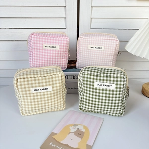 Macro view of checkered fabric sanitary bags with MAY RABBIT labels and side metal ring