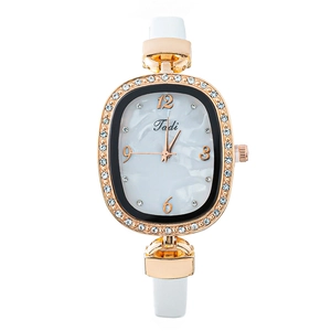 Montre femme élégante avec boîtier ovale or rose, lunette cristaux et bracelet cuir blanc