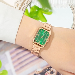 Elegant rose gold rectangular watch with a green sunburst dial shown on a woman wrist