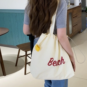 Cream nylon tote bag with red Beach letter print and adjustable drawstring closure