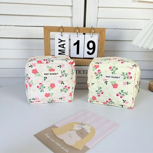 Detailed view of quilted cotton mini pouches with floral prints and zipper closure