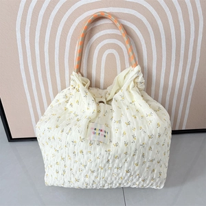 Detail of floral chiffon tote featuring pleated texture and braided rope handles