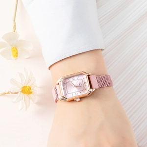 Primo piano dell'orologio rettangolare in oro rosa con cinturino in maglia rosa