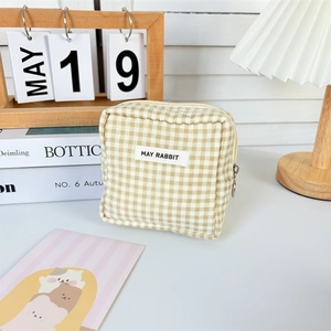 Close-up of minimalist beige checkered storage bag with zipper and branded label