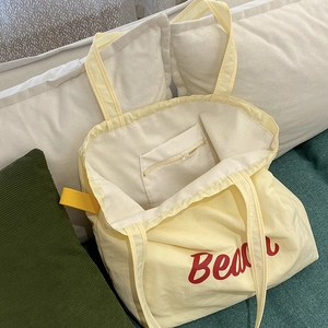 Light yellow nylon Beach tote bag with red lettering and internal zipper pocket