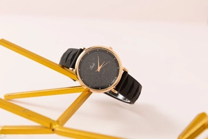 Detail of rose gold starry dial watch on artistic stand showing texture on silicone strap