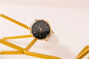 Dettaglio dell'orologio Tadi con cassa oro rosa e quadrante stellato su supporto dorato