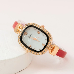 Elegant rose gold square watch with crystal bezel and red leather strap on stone display