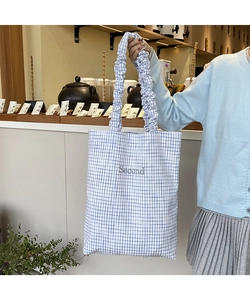 Dettaglio della borsa tote a quadretti blu con tracolla a ruches e ricamo Second