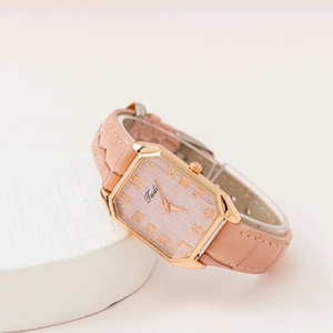 Primer plano de reloj de mujer con caja rectangular de oro rosa y correa de cuero rosa