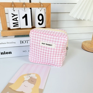 Macro detail of pink checkered fabric pouch showing zipper closure and May Rabbit label