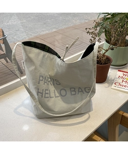 Detail view of large tote bag with Paris lettering and green plaid inner lining
