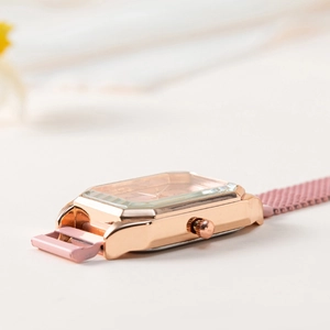 Dettaglio dell'orologio quadrato oro rosa con vetro sfaccettato e cinturino in maglia