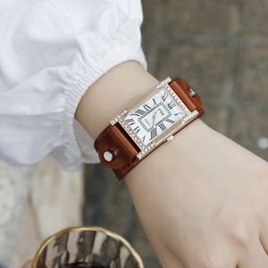 Detail of a ladies vintage rectangular quartz watch with crystal bezel and brown leather strap