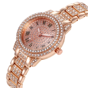 Detailed close-up of rose gold watch with sparkling crystals and Roman numerals dial