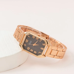 Détail du cadran carré noir avec chiffres en or rose et bracelet en acier inoxydable