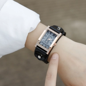 Detail of a rectangular quartz watch with crystal-set case and studded leather strap
