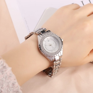 Gros plan d'une montre de luxe argentée avec lunette en strass sur le poignet d'un mannequin