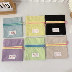 Set of six macaron-colored canvas pouches with contrasting zippers and ring pulls