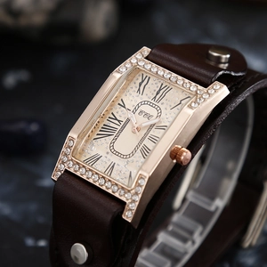 Detail of rose gold rectangular watch case with rhinestones and brown leather strap